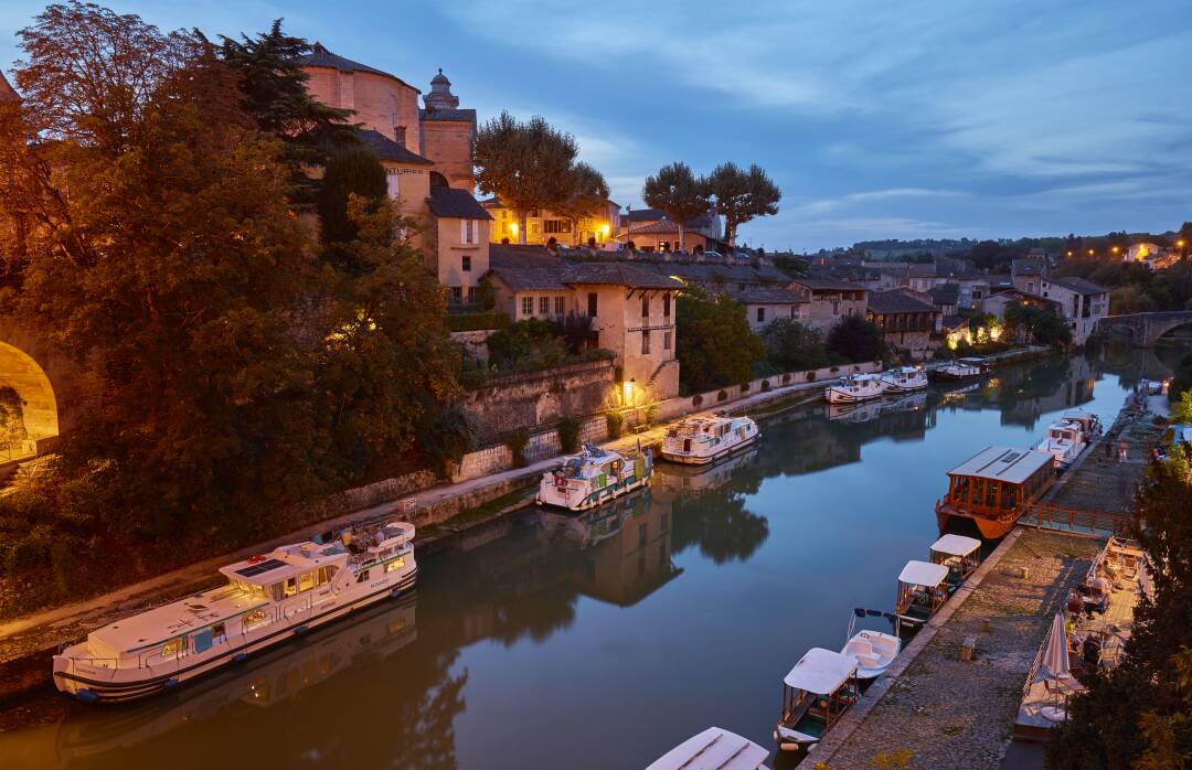 N&eacute;rac und sein Hafen, einer der sch&ouml;nsten Frankreichs: Der Hafen von N&eacute;rac liegt mitten im Herzen der Stadt und bietet Ihnen ein au&szlig;ergew&ouml;hnliches Panorama zwischen Pont Vieux und Pont Neuf. Am linken Ufer sehen Sie das Ch&acirc;teau-Mus&eacute;e Henri IV und die Kirche Saint-Nicolas. Am rechten Ufer erstrecken sich die Fassaden und D&auml;cher von Petit N&eacute;rac und seiner Kirche Notre-Dame.